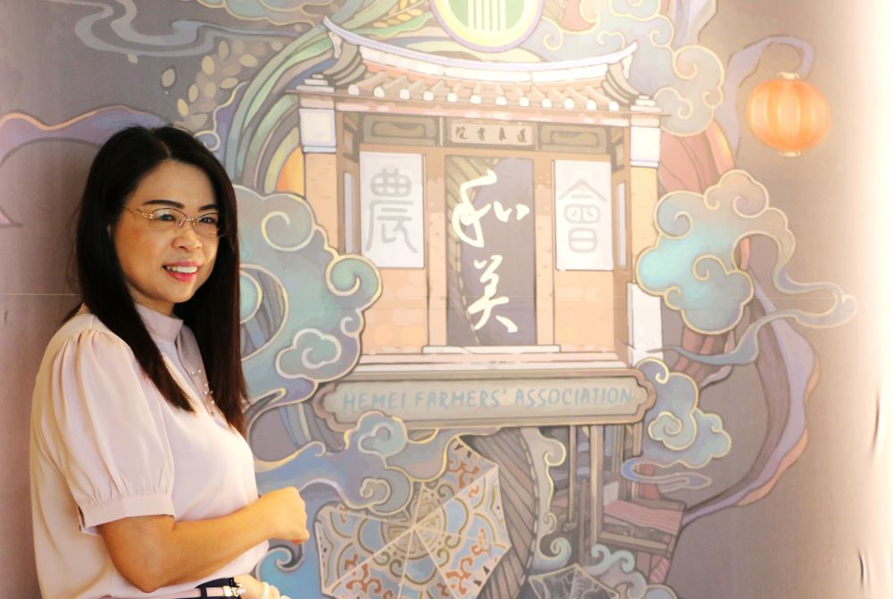 總幹事謝燕如介紹農遊館玄關牆面的圖繪，融合和美書院、稻米、雨傘、紡織等四大元素。